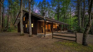 A cabin with a porch, a large window, and a wooden deck.
