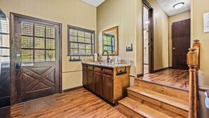 A wooden staircase leading to a second floor, a kitchen area with a countertop and cabinets, and a door with a window. - 3 Bedroom 2.5 miles from Rocky top sports complex (Sevierville)