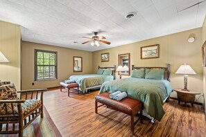 Una habitación con dos camas, ventilador de techo y ventana.
