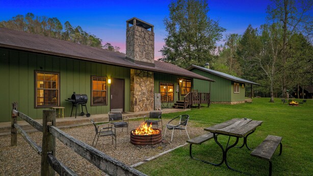 A rustic lodge with a stone chimney, outdoor seating, and a fire pit. - 3 Bedroom 2.5 miles from Rocky top sports complex (Sevierville)