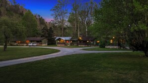 A lodge with multiple cabins, a gravel driveway, and a car parked in front.