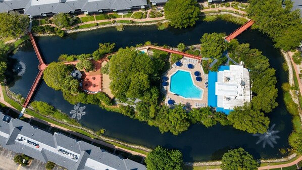 An aerial view of a property with a swimming pool, a red bridge, and a dock. - Park Shore Resort-Deluxe Condo, water views #232 (Park Shore Resort)