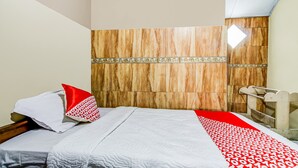 A hotel room with a wooden headboard, a bed with a white and red patterned bedspread, and a small window with a view of the outside. - OYO 91053 Desa Wisata Gilimanuk (Malang)