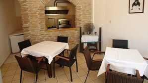 Un comedor con paredes de piedra, horno empotrado y pequeña zona de cocina.