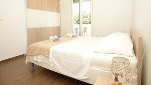 Un dormitorio con cama, ventana y vista al exterior.