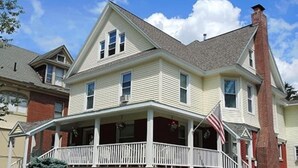 A two-story house with a front porch and a chimney. - Team Elm (Entire Property) (Oneonta)
