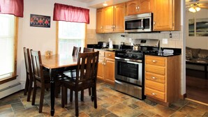 A kitchen with wooden cabinets, a stainless steel oven, and a microwave. - Team Elm (Entire Property) (Oneonta)