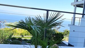 A modern building with a balcony overlooking a body of water.