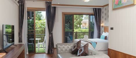 Una sala de estar moderna con sofá, televisor y un balcón con mobiliario exterior.