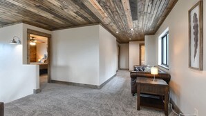 Ein geräumiger Korridor mit Holzboden, einer Sitzecke mit Sofa und Tisch sowie einem gerahmten Bild an der Wand.