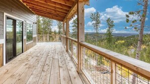 Eine Holzterrasse mit Blick auf eine bewaldete Landschaft.