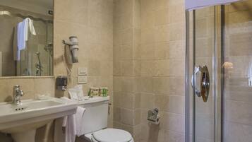 Een badkamer met toilet, wastafel en douche.