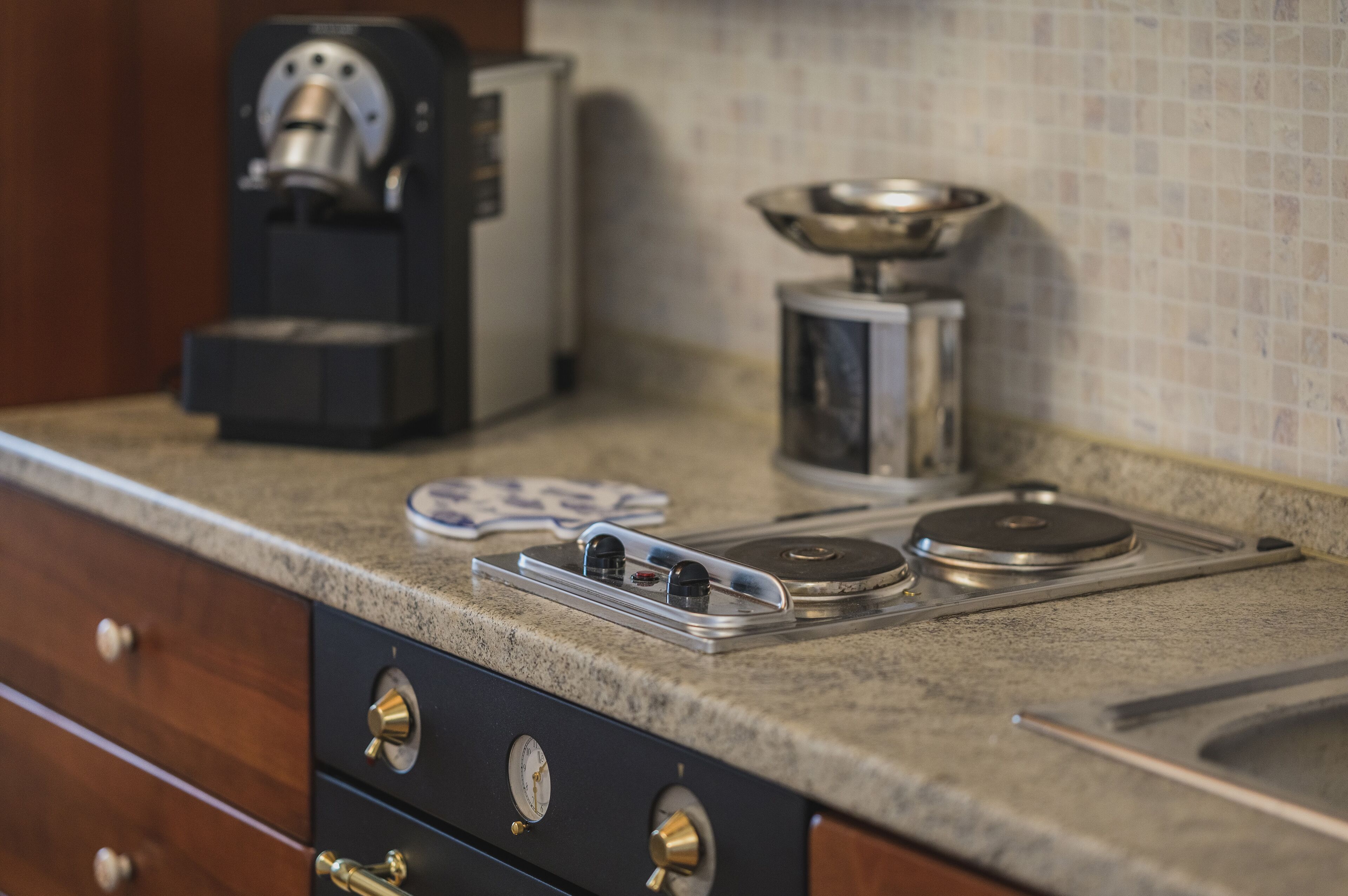 A kitchen counter with a coffee maker, a scale, and a timer.