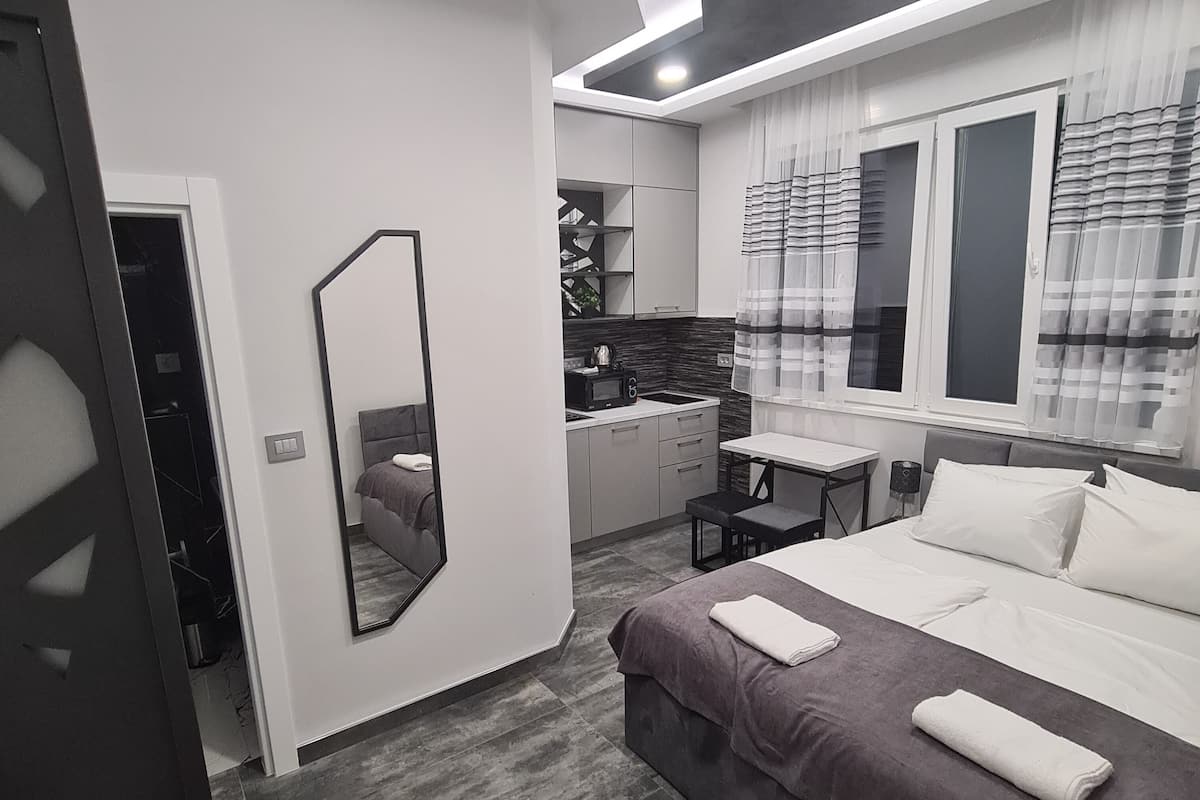 Un dormitorio moderno con una cama grande, un escritorio y un espejo.