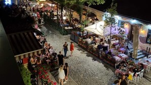 An outdoor dining area with tables and chairs, surrounded by buildings and trees. - UP accommodation (Belgrade)