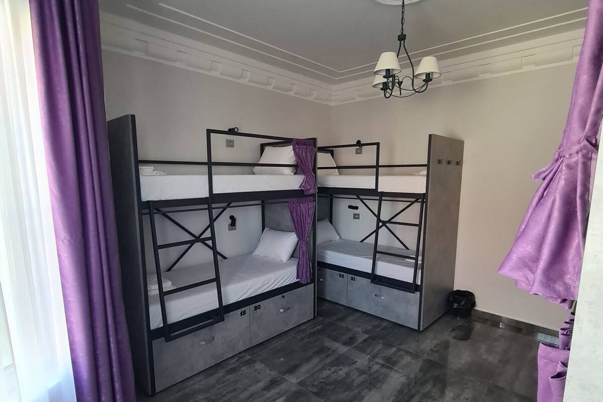 Una habitación con literas, un armario y una araña.