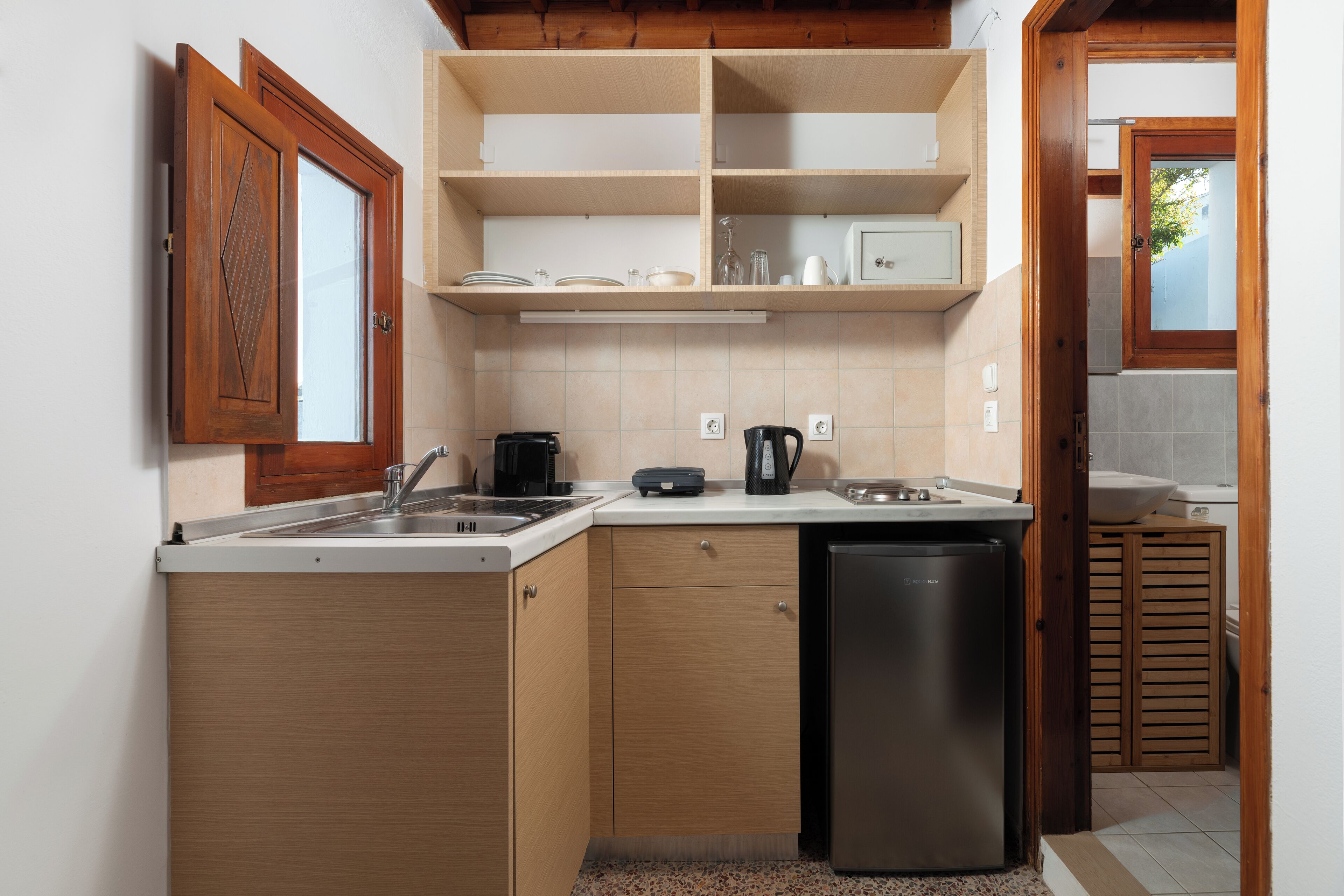 Una cocina funcional con lavavajillas, cafetera y pileta.