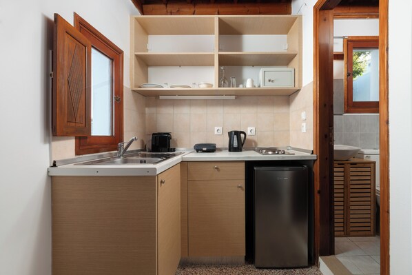 A compact kitchen with a dishwasher, a coffee maker, and a sink. - Arte Lindos Suites (Rhodes)