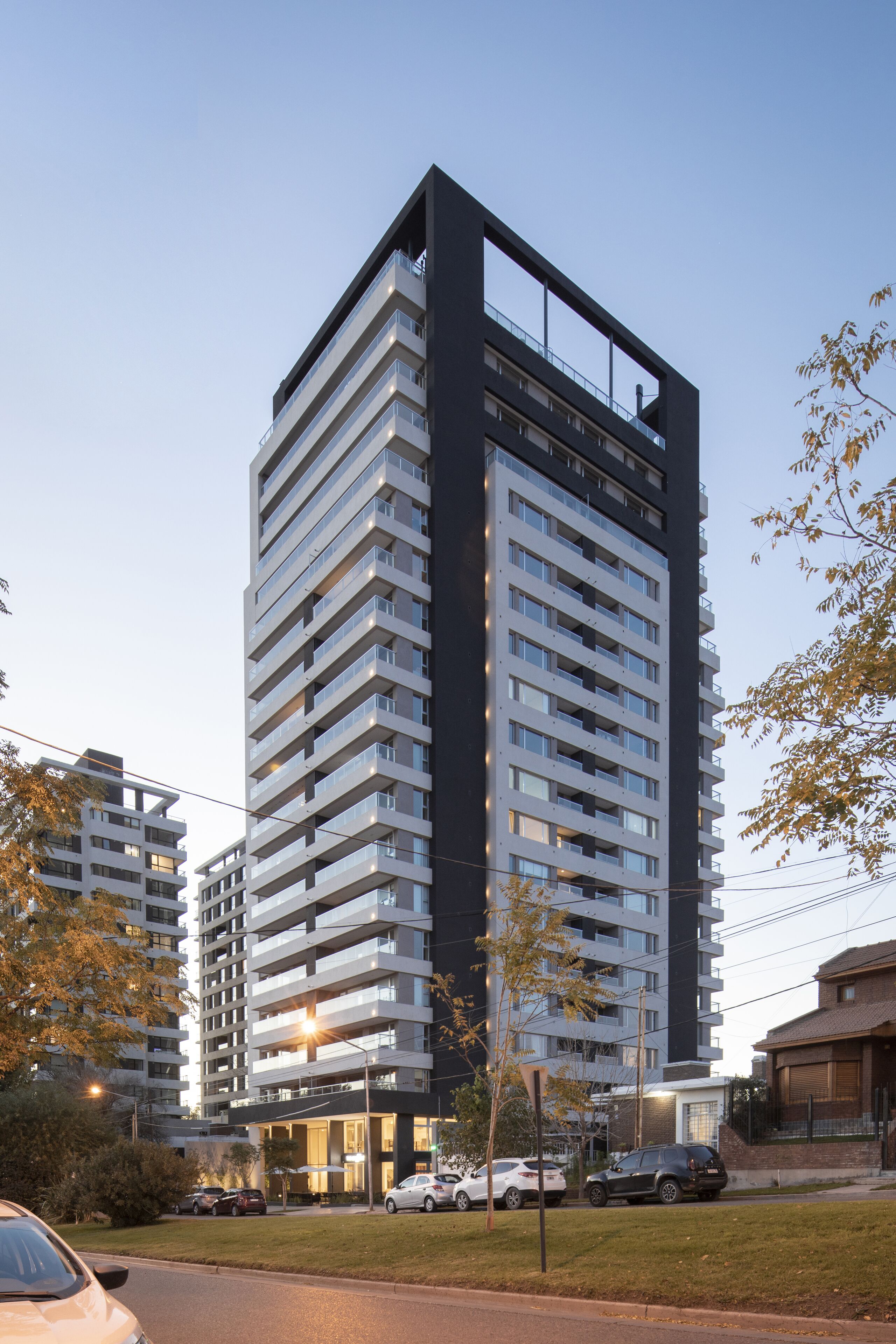 A modern high-rise building with multiple balconies and a flat facade.