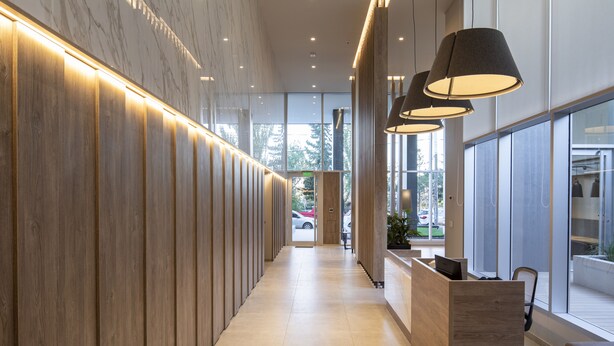A modern hotel lobby with a wooden reception desk, large windows, and pendant lighting. - Dots del Alto (Neuquén)