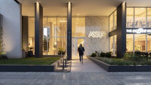 A modern building with a glass facade, a prominent 'ASSUR' sign, and a coffee shop visible through the windows. - Dots del Alto (Neuquén)