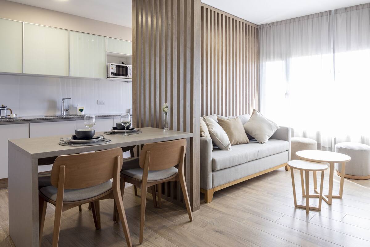 Um espaço de estar moderno com cozinha, sala de jantar e área de estar.
