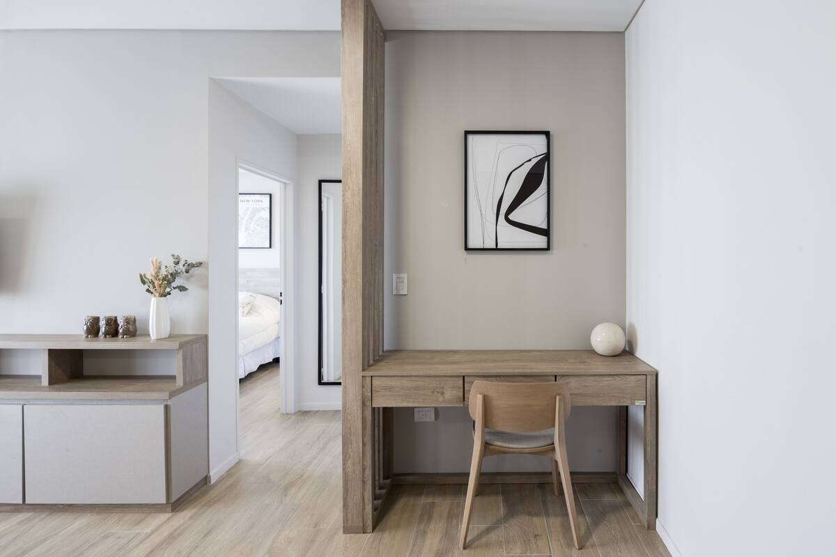 Quarto moderno com escrivaninha de madeira, uma cadeira e uma cama.