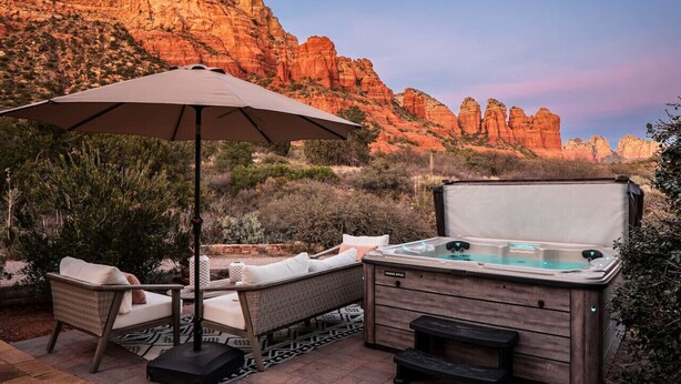 A hot tub with a wooden exterior, a lounge chair, and an umbrella in a desert landscape. - Sedona`s Oceanfront Property • Spa, Views, Trails! (Sedona)