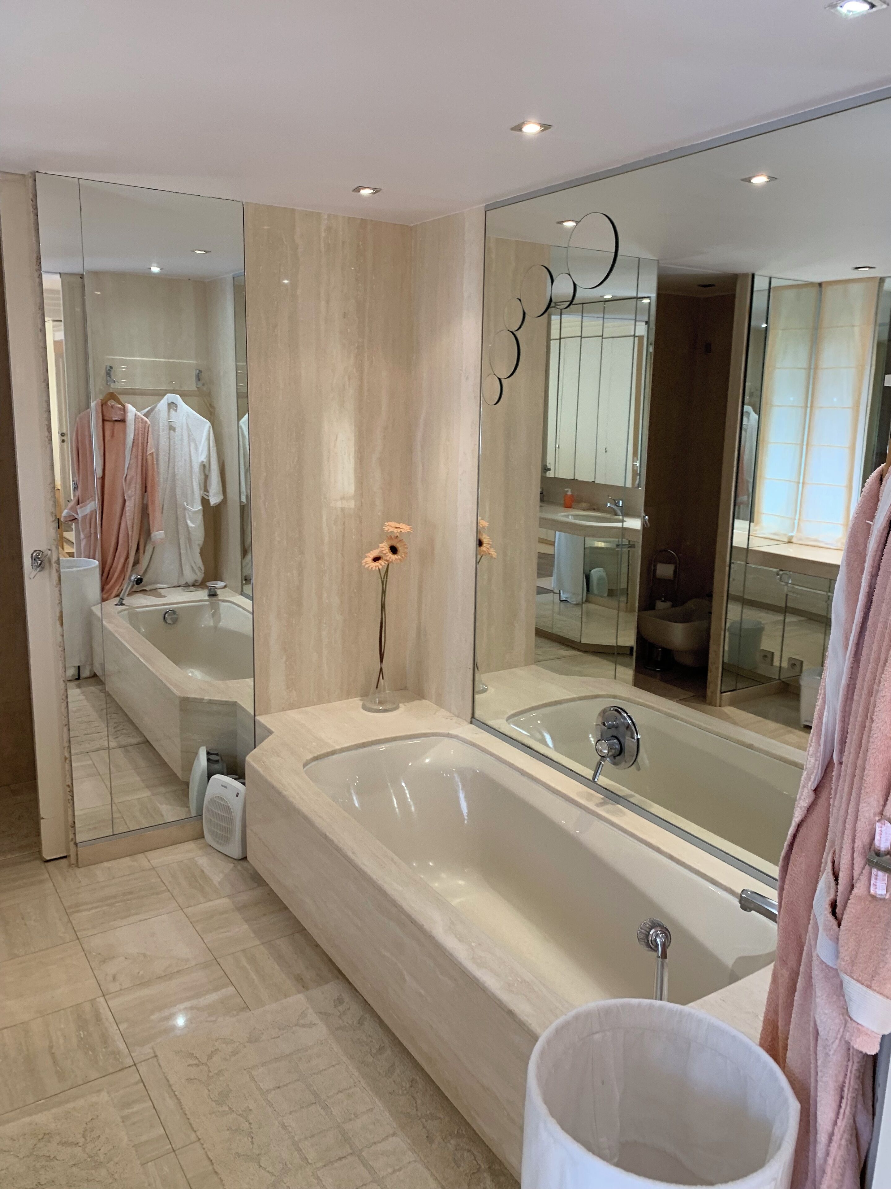 A modern bathroom with a large bathtub, a walk-in shower, and a vanity with a mirror.