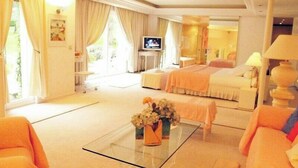 A hotel room with a glass coffee table, a bed, a sofa, and a television. - Large 600M2 property, tennis and 60sqm pool house with bar-kitchen on 10000 sqm (Mougins)
