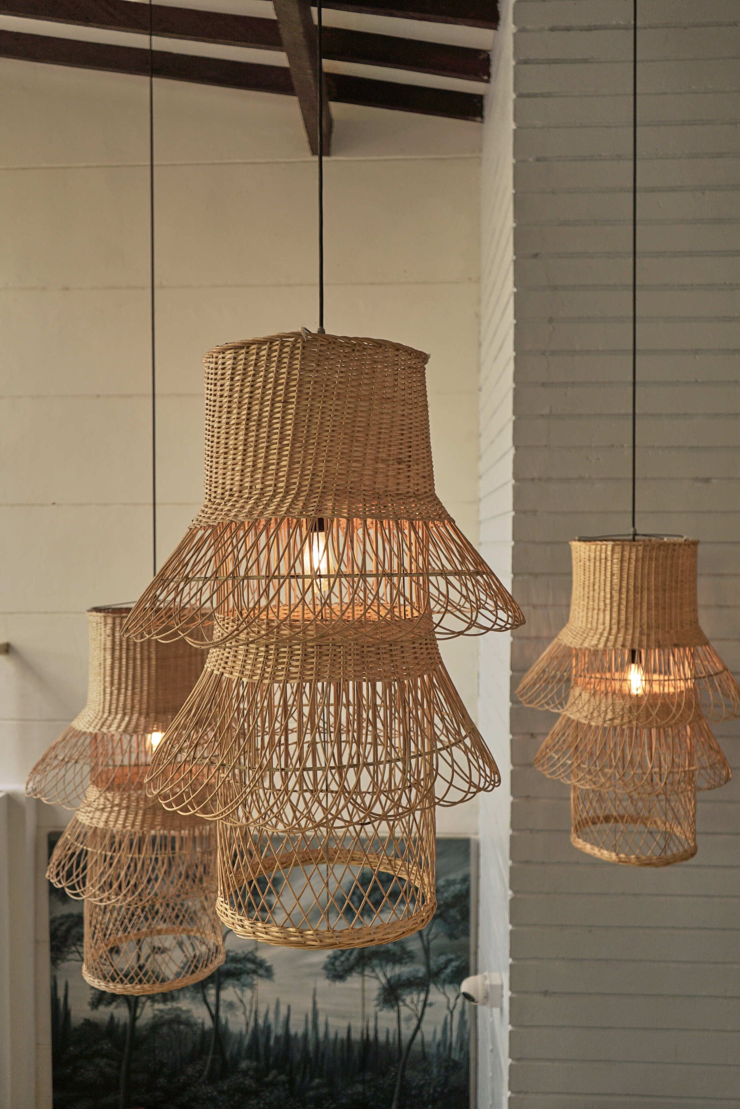 A room with three wicker pendant lights hanging from the ceiling.