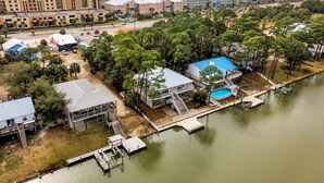 An aerial view of a coastal area with a hotel, a swimming pool, and a dock extending into a body of water. - Screamin' Peace 1614 Cadillac 3 Bedroom Home by RedAwning (Dauphin Island)