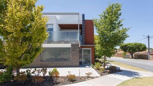 A modern two-story building with a flat roof, large windows, and a brick facade. - Stirling Apartment 1- Modern Central Apartment (Yokine)