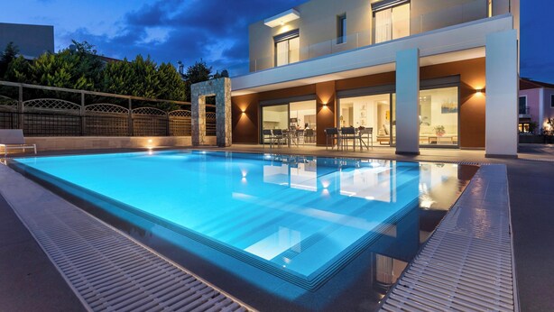 A modern hotel with a swimming pool, outdoor seating, and a well-lit entrance. - Ialysos Charme Villa (RHODES)