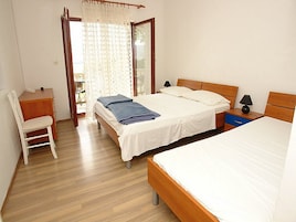 A bedroom with two beds, a desk, and a chair.
