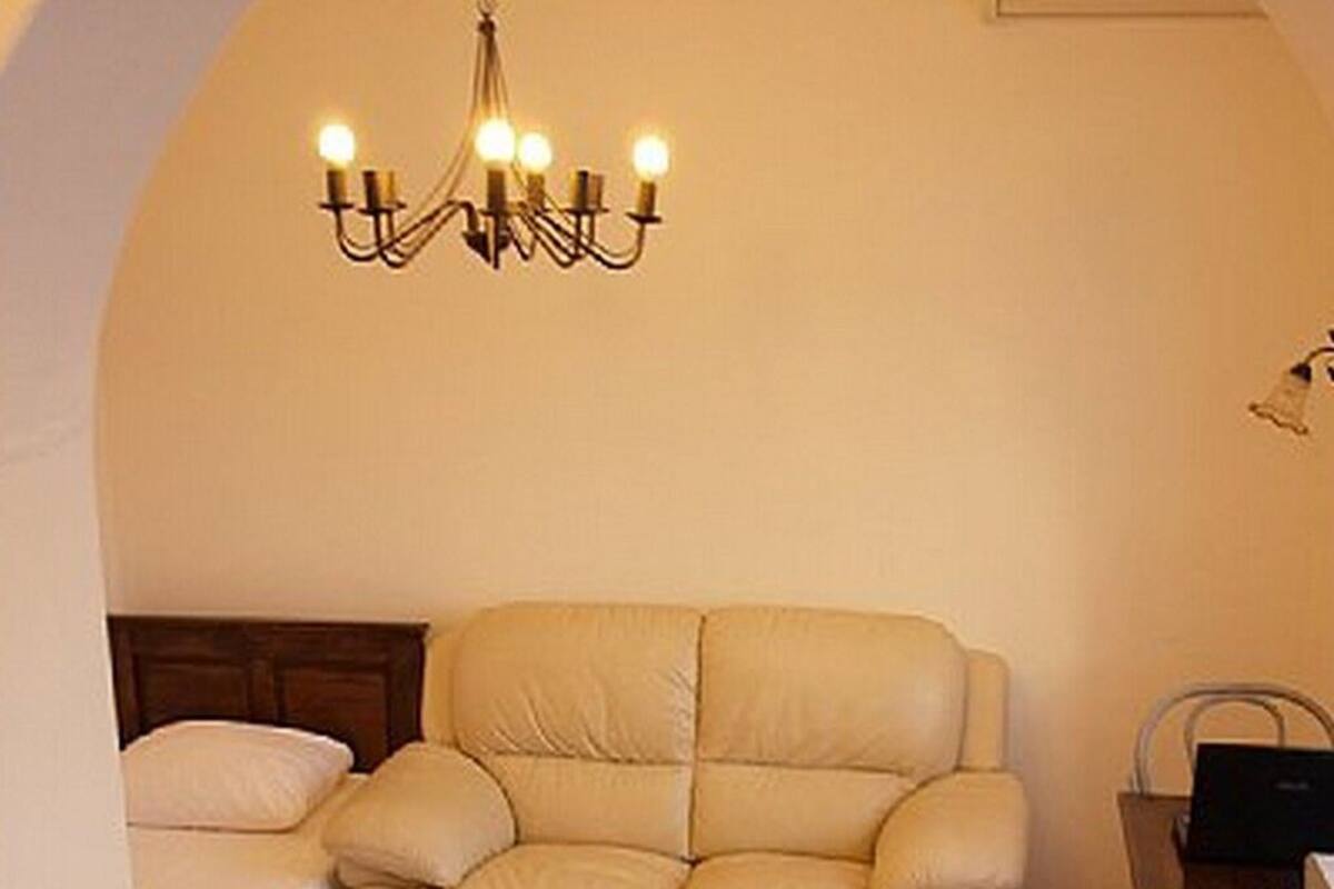 A cozy room with a beige sofa, a wooden coffee table, and a chandelier.