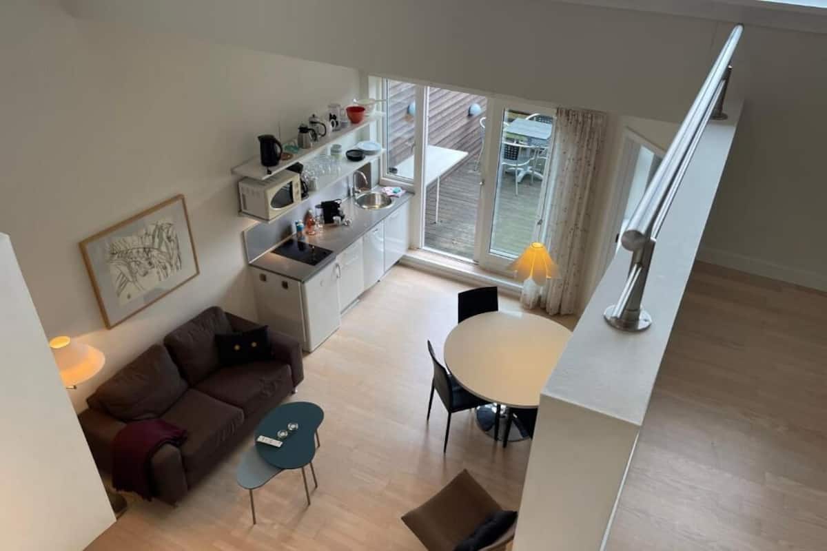 A modern apartment with a kitchen, dining area, and a living room.