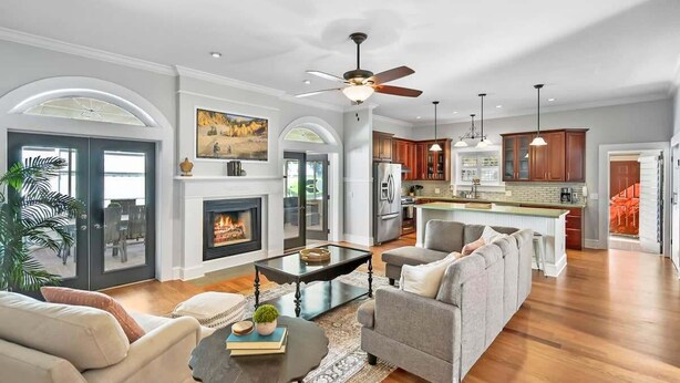 A spacious living room with a fireplace, a dining area, and a kitchen with wooden cabinets. - Beach House, Pool, Golf Cart, Game Room, BBQ, (St. Augustine)