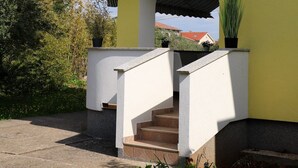 A two-story building with a balcony and a staircase leading to the entrance. - Apartment Marina (Punat)