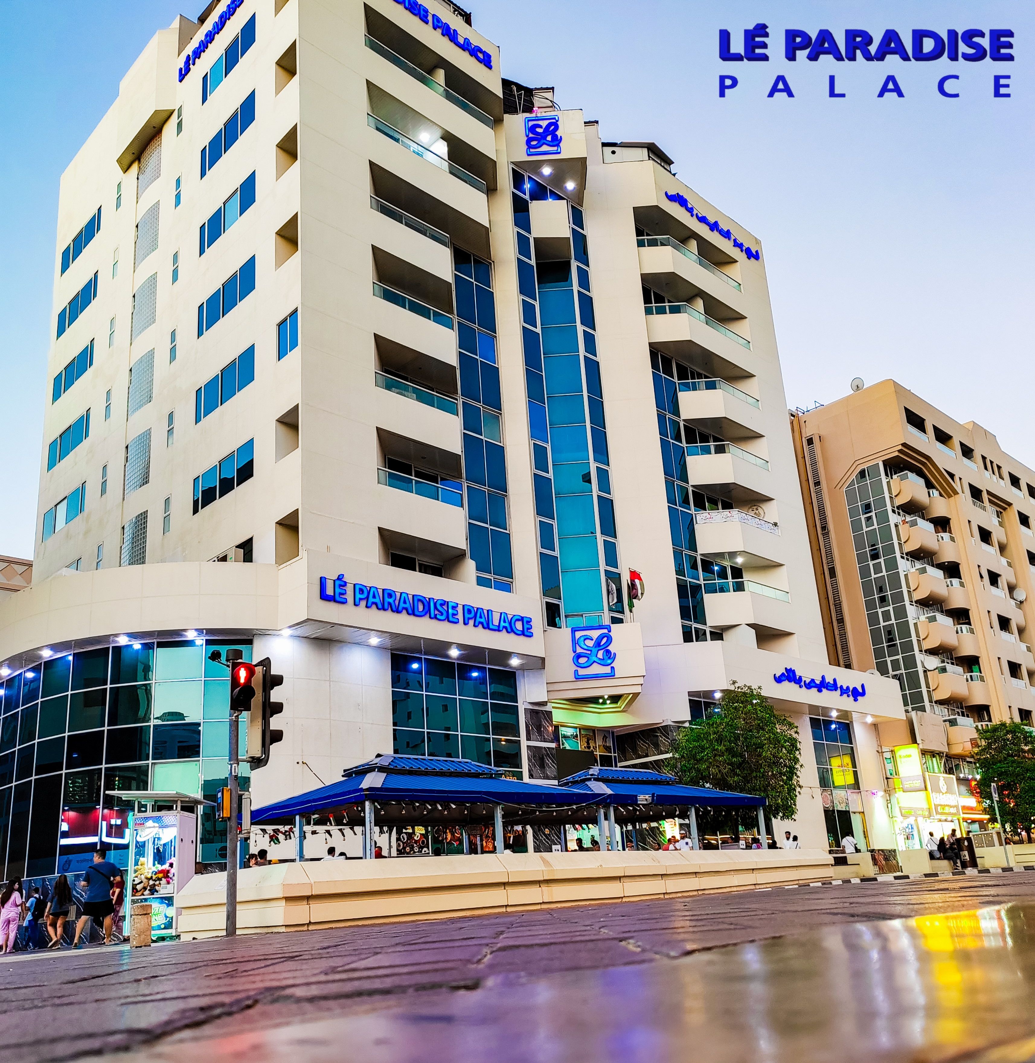 A multi-story hotel with a prominent sign reading "Lé Paradise Palace".