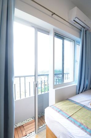 Relax on the balcony with a view, featuring a comfortable bed and stylish decor.