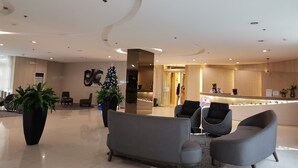 Un vestíbulo moderno con mostrador de recepción, zona de estar y un árbol de Navidad.