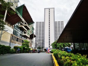Stunning cityscape with a high-rise building and lush greenery along the street.