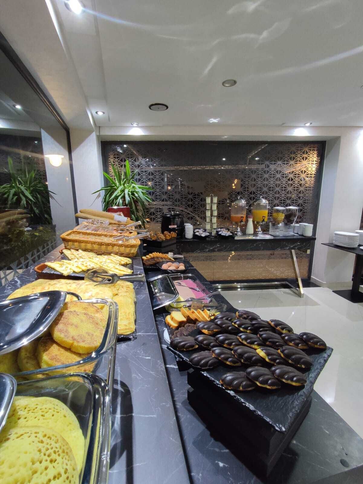 A buffet with various food items, including waffles, pastries, and a selection of fruits and vegetables.