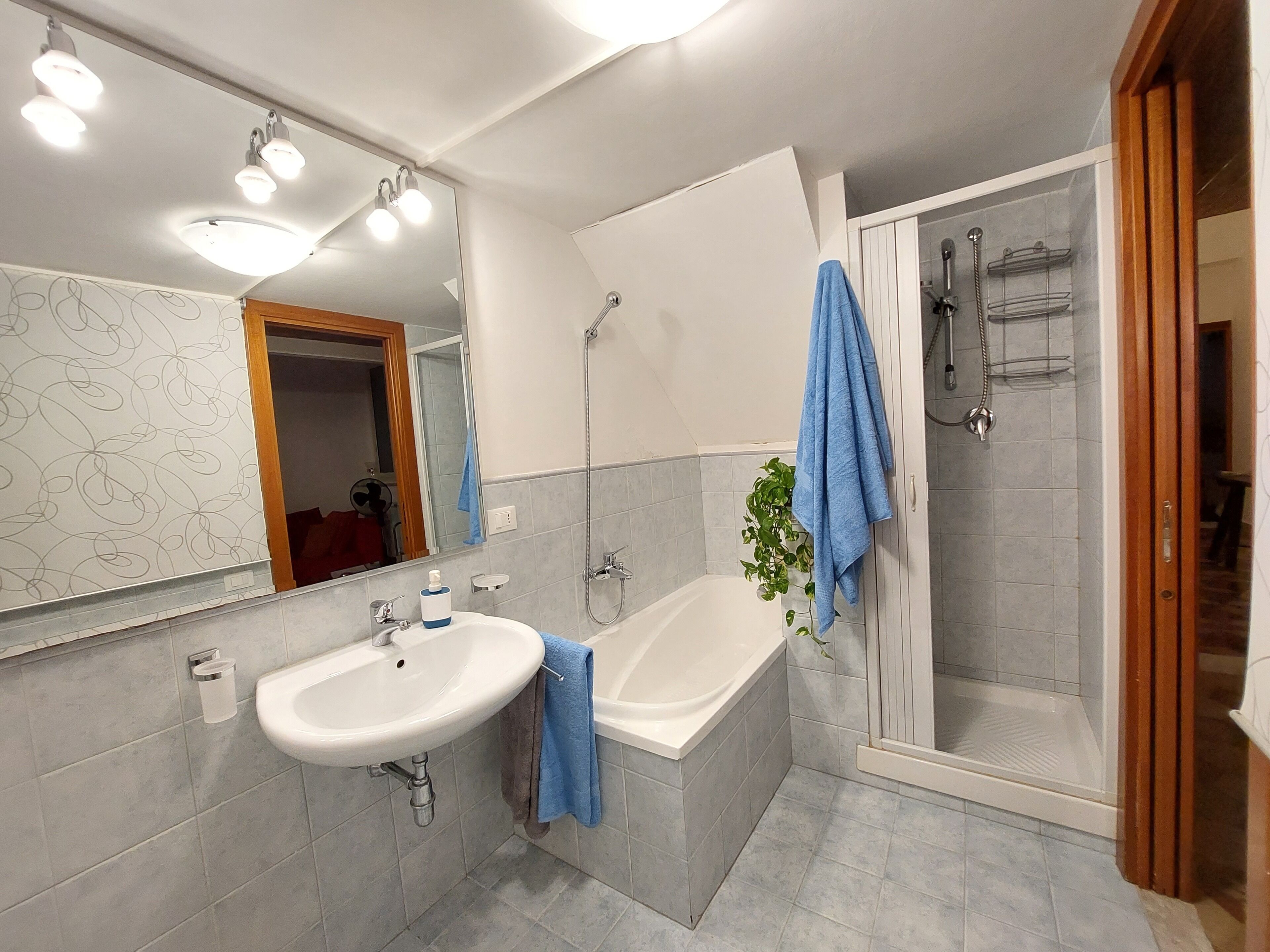 Een moderne badkamer met een wastafel, bad en douche.