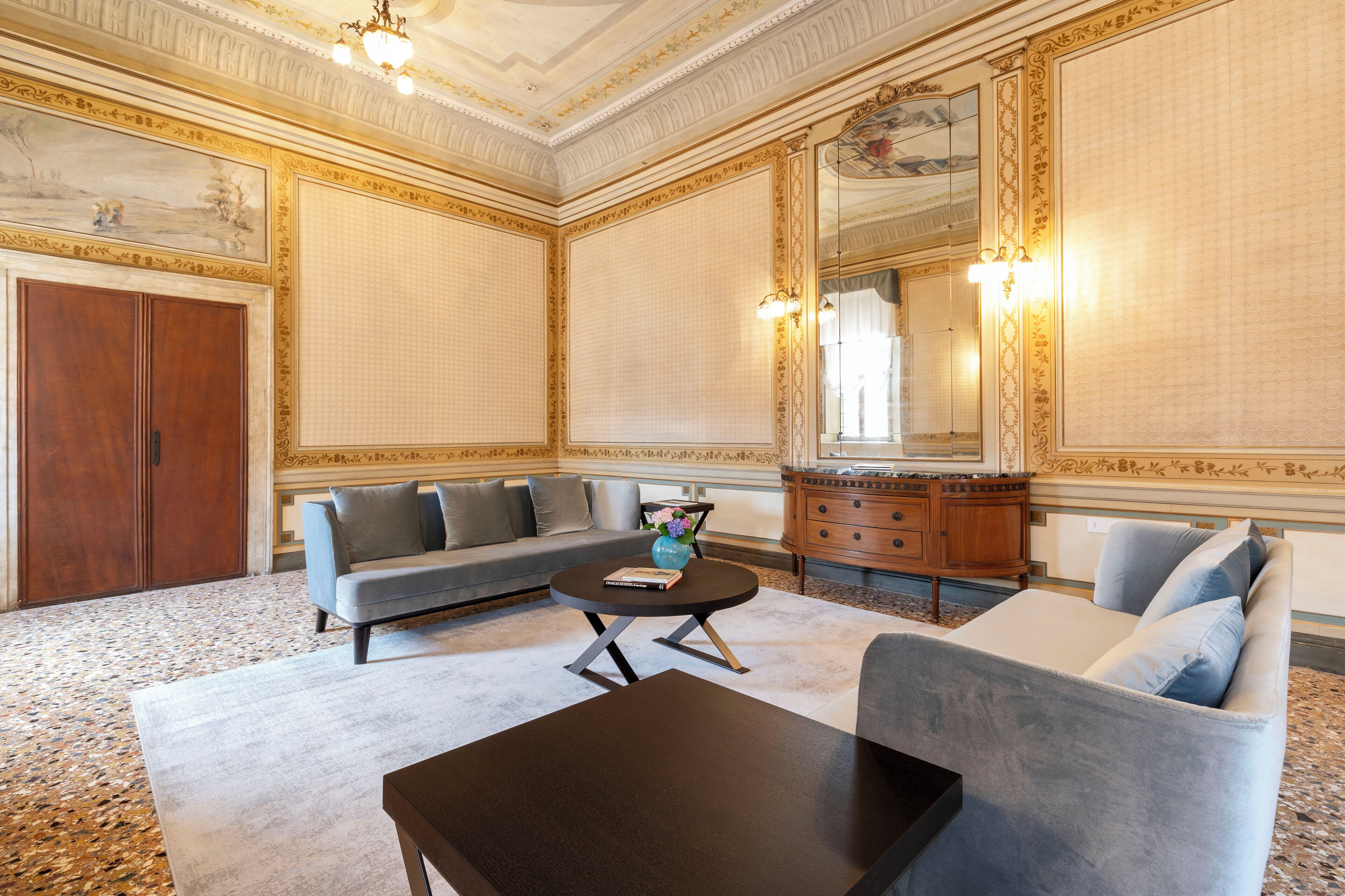 Une pièce spacieuse comprenant un grand canapé, une table basse ronde et un meuble en bois.