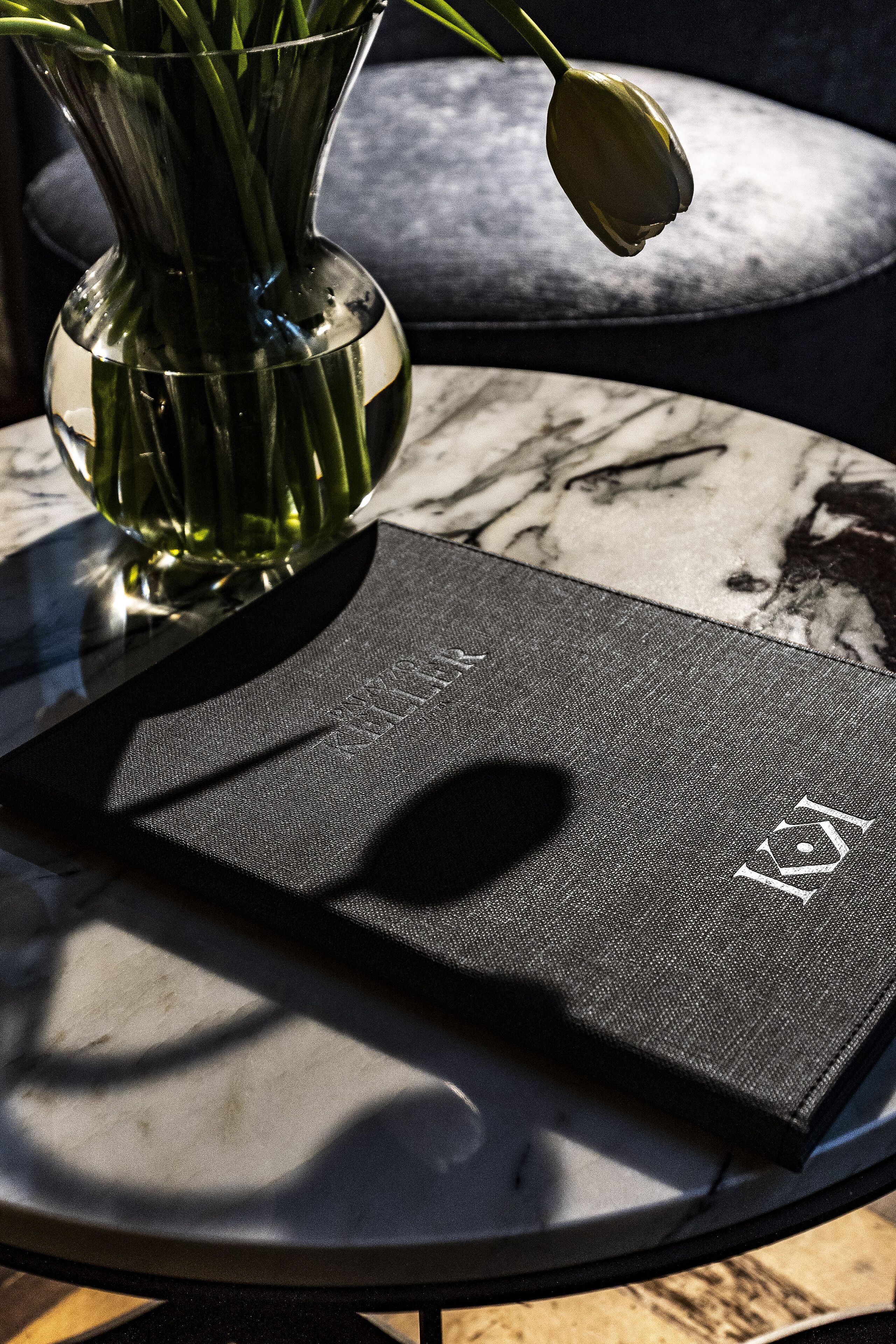 A clear view of a book titled "KIRK" on a table with a marble pattern.