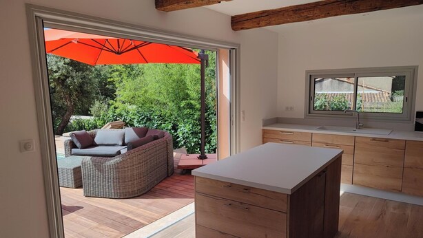 A modern kitchen with wooden cabinets and a large window. - VILLA LA TREILLE (Saint-Maximin-la-Sainte-Baume)