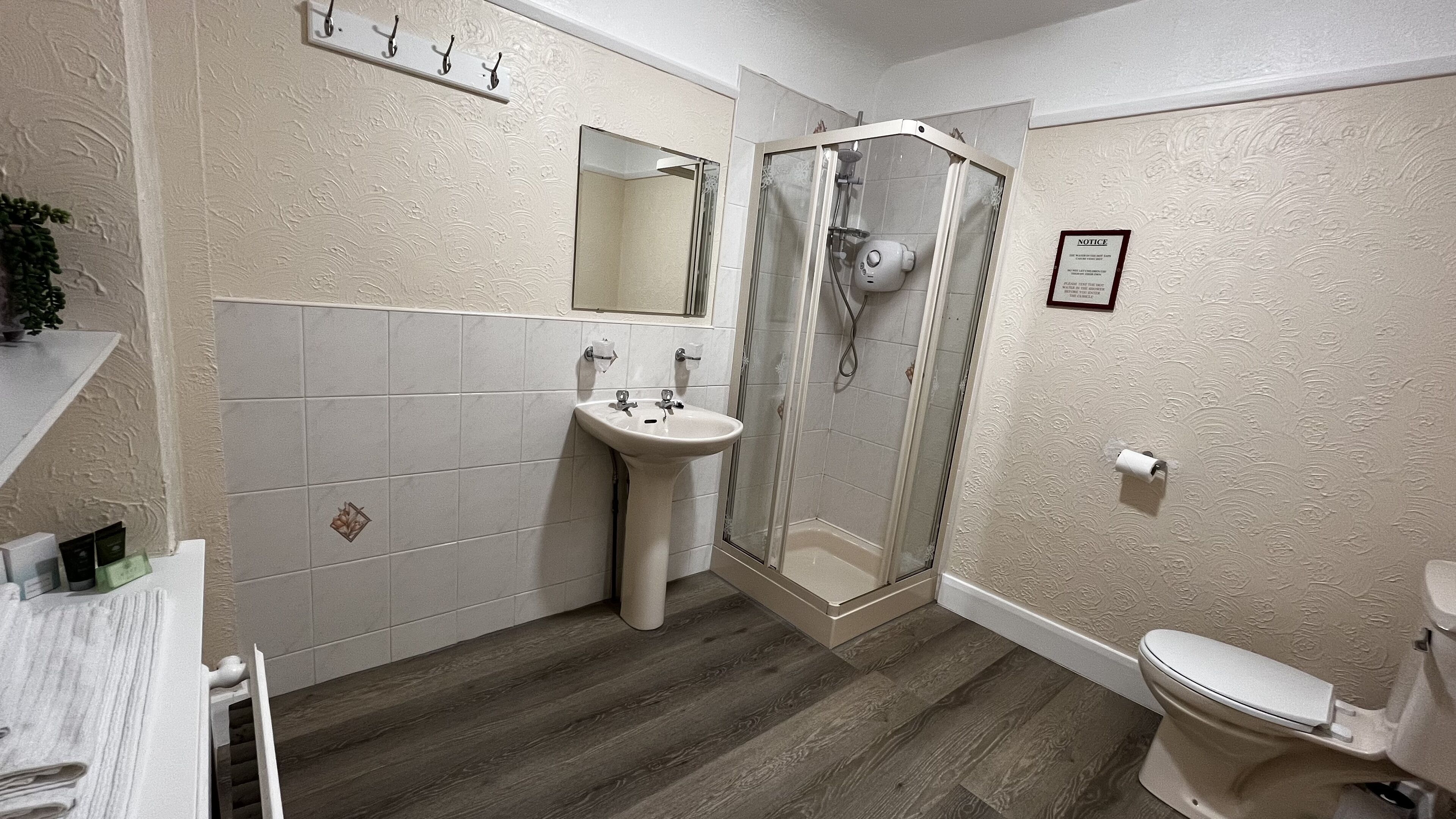 A bathroom with a shower, sink, and toilet.