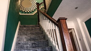 A staircase with a wooden handrail and a circular wall decoration.